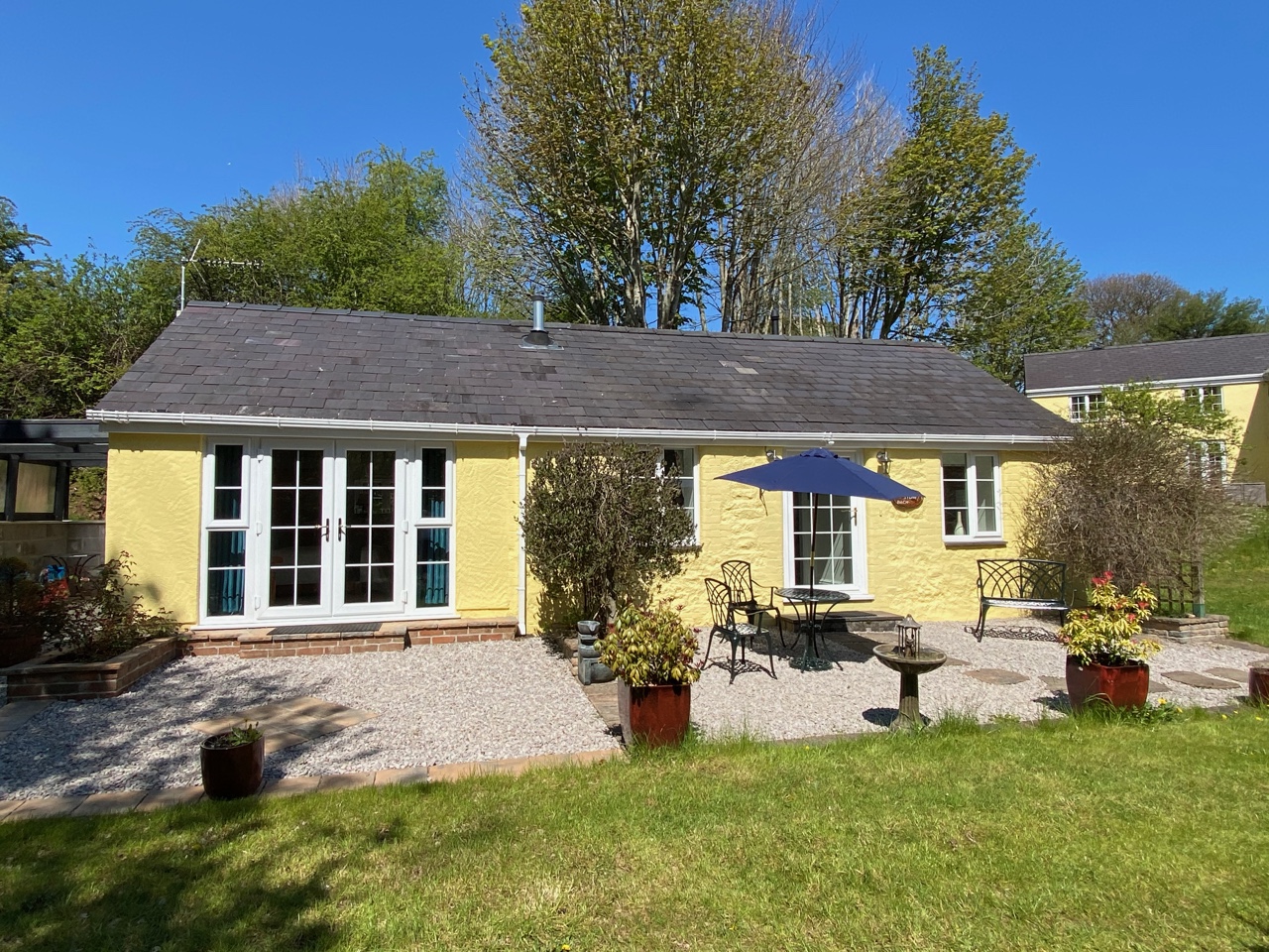 Exterior - patio with garden bench, dining table and chairs and parasol 5-star self catering Accommodation near Bangor, North Wales